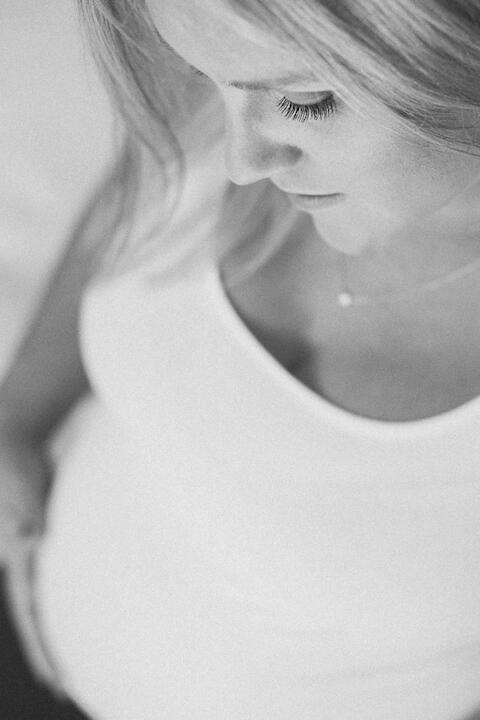 Calm, unhurried, made for you Close up on a pregnant woman, simple white dress, natural light